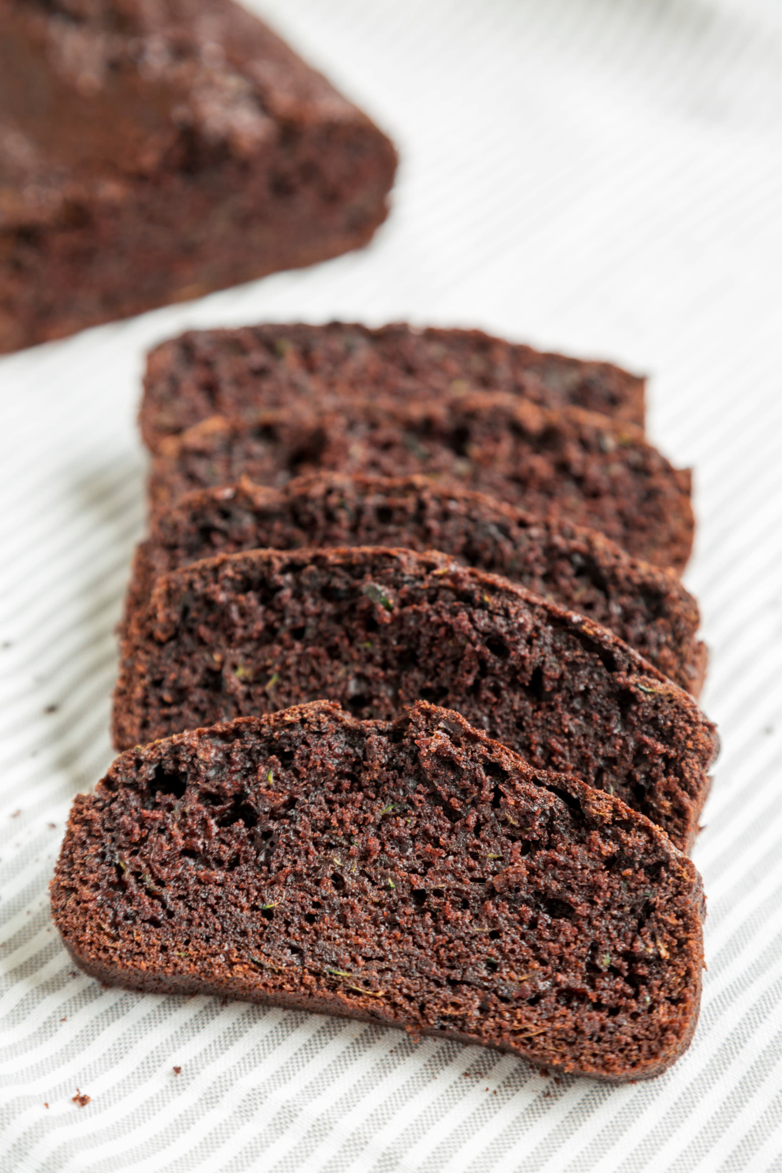 Homemade chocolate zucchini bread on a rustic wooden board, side view