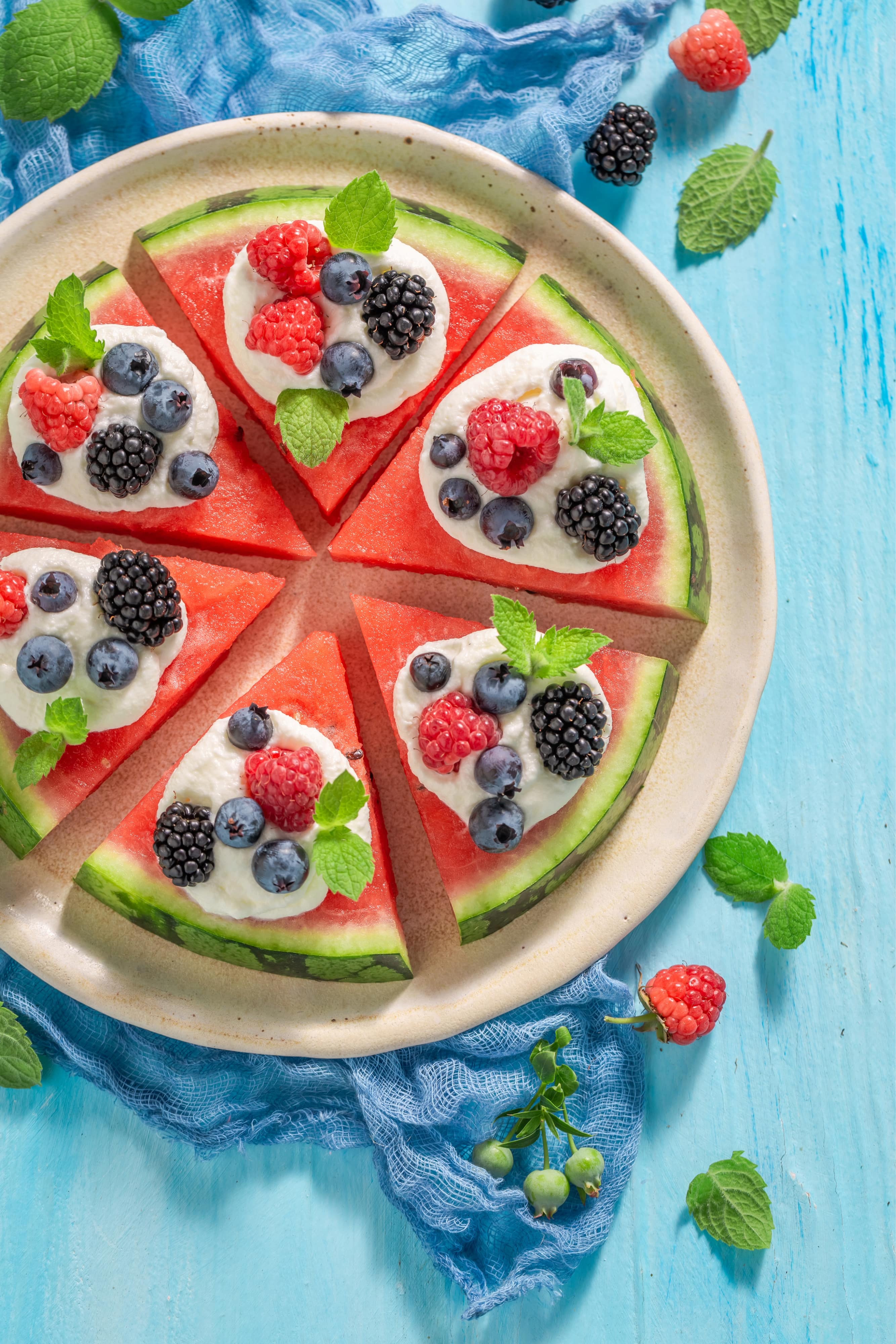 Juicy and sweet watermelon pizza with berries, cream and mint