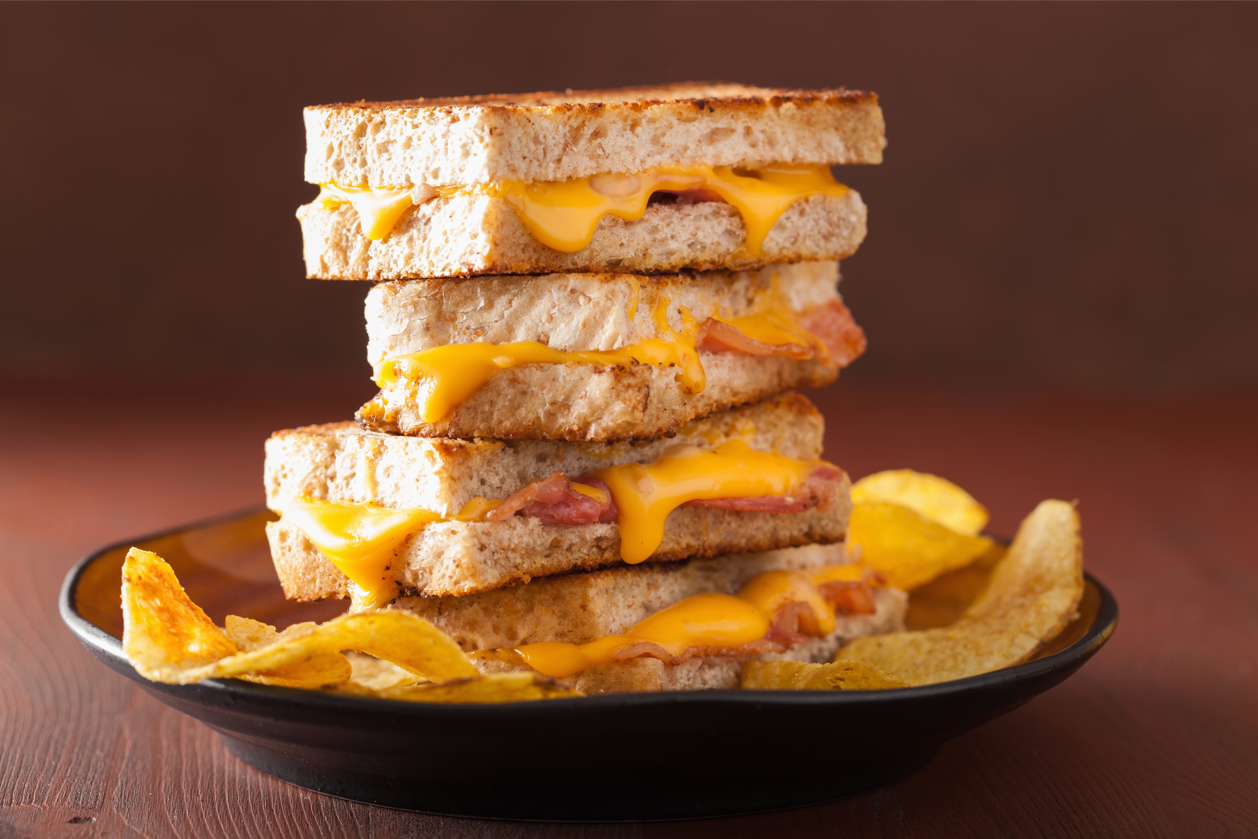 Close-up of a plate containing a stack of three grilled cheese sandwiches