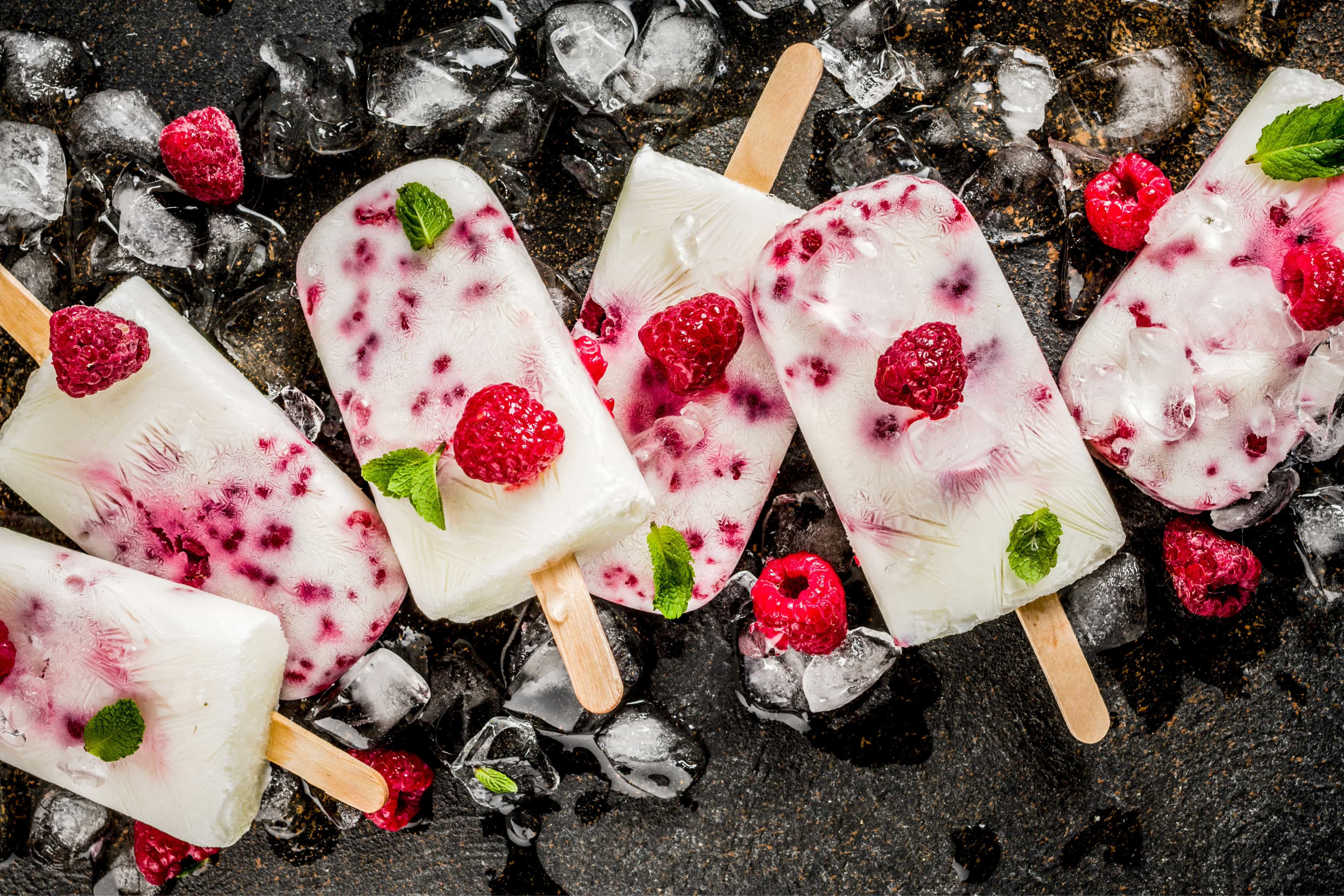Summer sweet desserts, homemade organic ice cream popsicles from raspberry and yogurt, dark rusty background copy space
