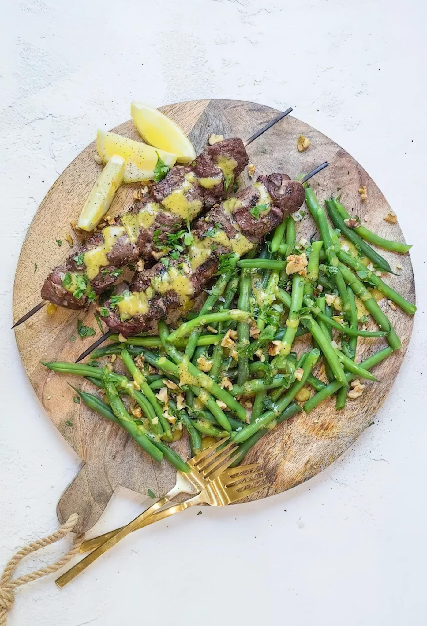 Close-up of steak kabobs with dijon green beans on cutting board
