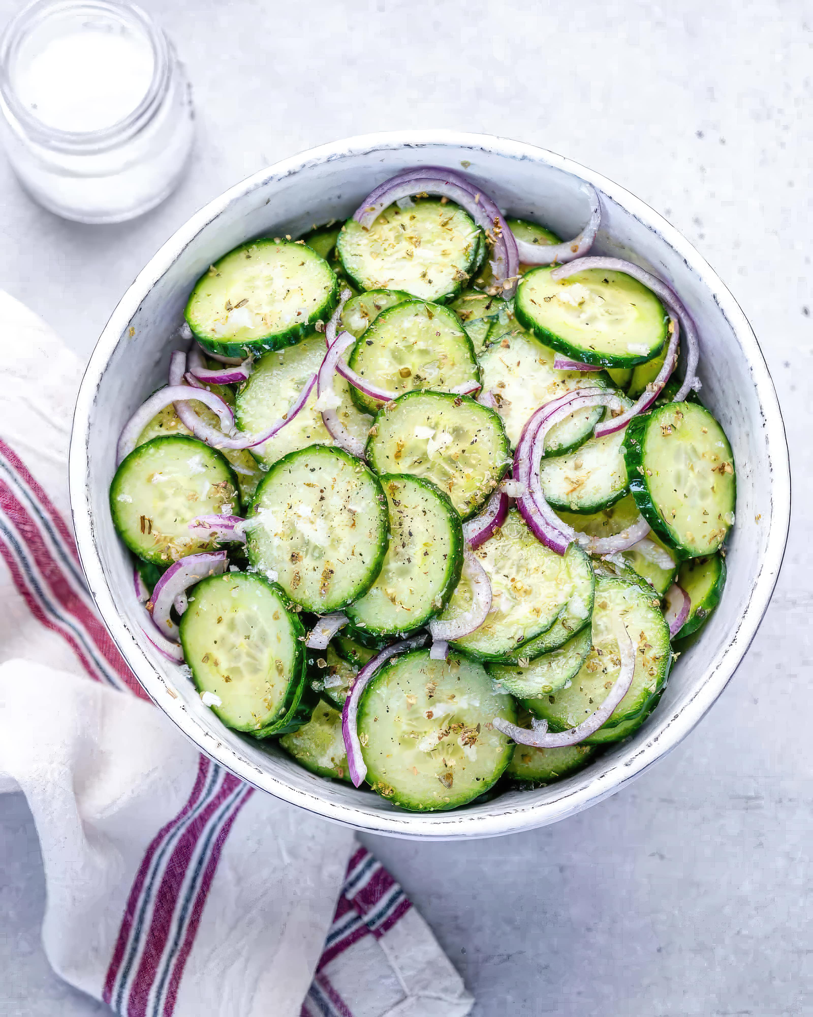 A bowl of fresh cucumbers, sliced and mixed with onions and red onions, ready to be served